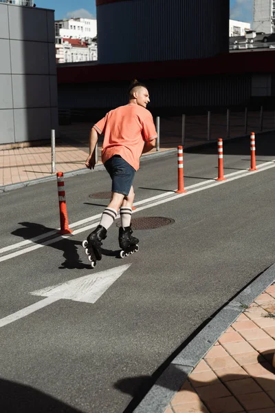 ローラースケートで男の側のビューは 都市の通りに道路上でスケート — ストック写真