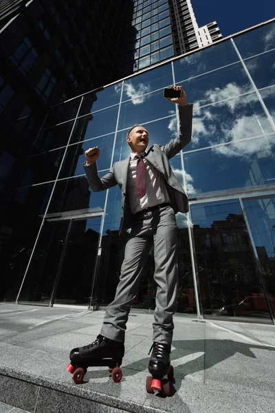 Χαμηλή Γωνία Άποψη Του Πατινέρ Επαγγελματικό Κοστούμι Κρατώντας Smartphone Και — Φωτογραφία Αρχείου