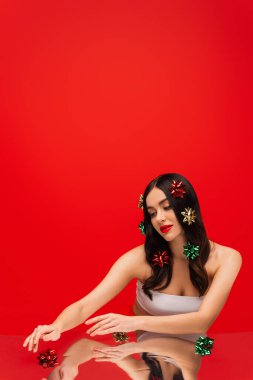 Dokunma yeteneği olan genç bir kadın kırmızı üzerine yansıtıcı bir yüzey ile eğiliyor. 