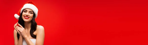 Весела Молода Жінка Капелюсі Санта Дивиться Камеру Ізольовано Червоному Банер — стокове фото