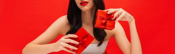 Widok Upraw Brunetka Kobieta Makijażu Gospodarstwa Pudełka Upominkowe Izolowane Czerwono — Zdjęcie stockowe