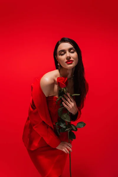 Femme Élégante Veste Posant Avec Fleur Rose Isolée Sur Rouge — Photo