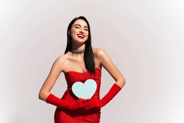 グレーに隔離された赤いドレスと手袋保持紙の心の肯定的なモデル — ストック写真