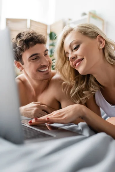 Blonde Woman Using Blurred Laptop Shirtless Boyfriend Bedroom — Stock Photo, Image