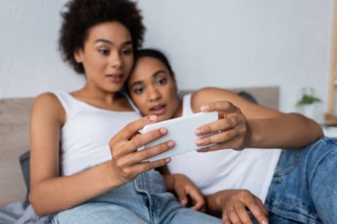 Afro-Amerikan lezbiyen çiftin yatak odasında akıllı telefon kullanmasına şaşırdım.