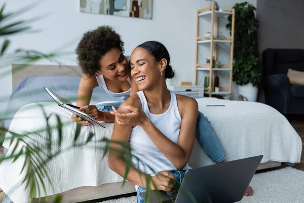 Gelukkig Afrikaans Amerikaanse Vrouw Zitten Met Laptop Wijzend Met Hand — Stockfoto