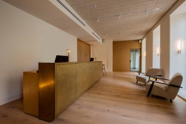 modern armchairs near reception desk in luxury hotel lobby 