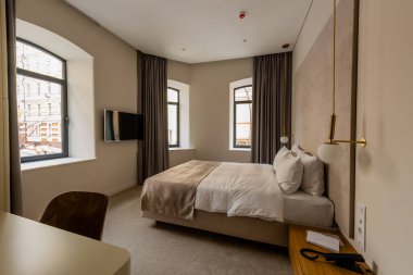 comfortable bed with pillows in modern hotel bedroom 