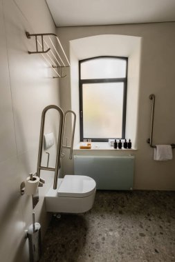 interior of modern bathroom with toilet for disabled people in hotel 
