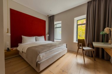 desk and wooden chair near modern bed in hotel 