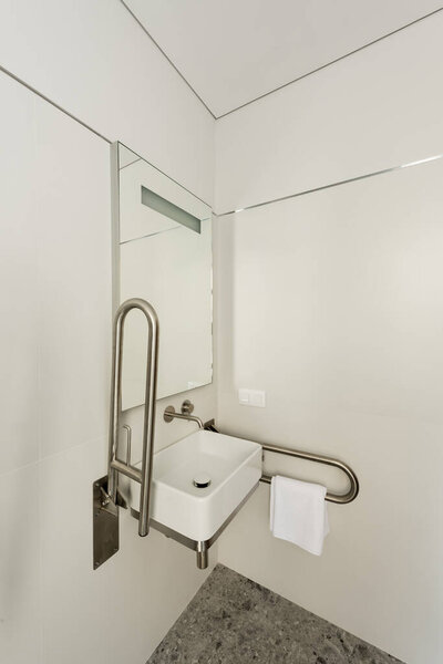 салон белой ванной комнаты с раковиной и зеркалом для инвалидов в отеле 