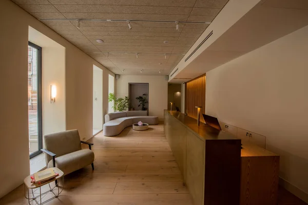 現代的なソファとアームチェアの近くにフロントデスク付きの高級ホテルロビーのインテリア — ストック写真