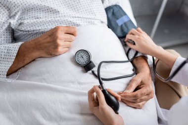 Tonometresi olan bir doktorun klinikteki yaşlı bir hastanın tansiyonunu ölçtüğü görüntüler. 