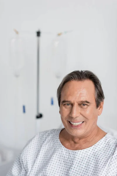 Positive Grauhaarige Patientin Blickt Auf Verschwommener Krankenhausstation Die Kamera — Stockfoto
