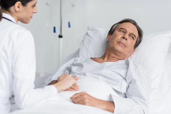 stock image Blurred doctor touching hand of upset patient in hospital ward 