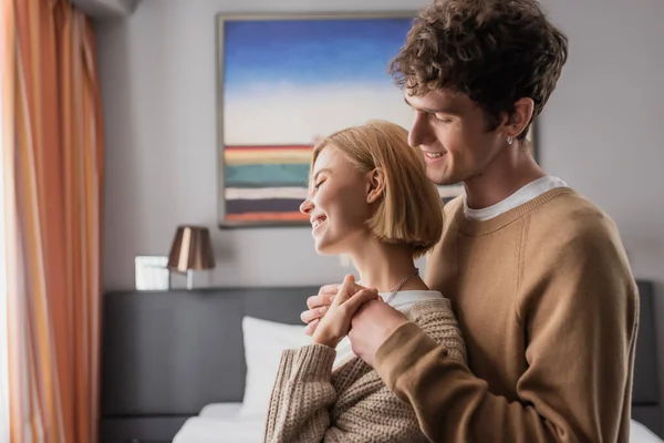 Side View Brunette Man Embracing Young Girlfriend Hotel Bedroom — Stockfoto