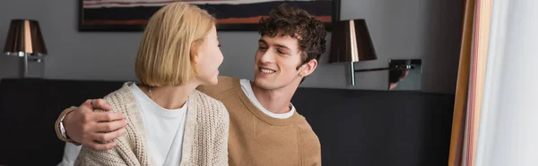 Smiling Brunette Man Hugging Blonde Girlfriend Hotel Room Banner — Stockfoto