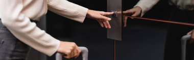 partial view of young woman pressing call button of elevator in hotel, banner