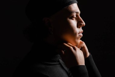 Afro-Amerikan balıkçı yakalı bir adamın profili. Yüzüne yakın poz veriyor. Siyahların üzerinde izole edilmiş.