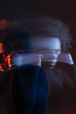 double exposure of abused african american man with hand near injured face looking at camera on dark with red and blue light clipart