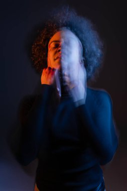 Yaralı Afro-Amerikalı yüzü kanlı adamın iki kez görüntüsü. Gözleri kapalı, kırmızı ve mavi ışıkta dikiliyor.