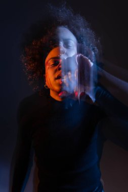 Siyahta bipolar bozukluğu olan, turuncu ve mavi ışık altında yaralı Afro-Amerikan bir adamın uzun süre maruz kalması.