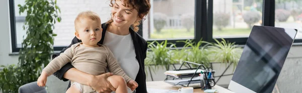 Smiling Businesswoman Holding Toddler Daughter Computer Monitor Blank Screen Office — Foto de Stock