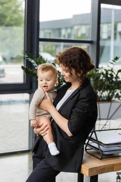 Businesswoman Black Suit Holding Little Child Work Desk Documents Office — Stock Fotó