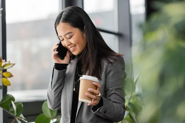 Positive Asian Designer Talking Mobile Phone Holding Takeaway Coffee Office — Foto de Stock
