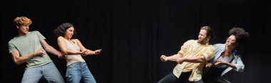 young interracial actors imitating pull rope game in theater, banner