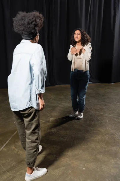 stock image multiracial woman rehearsing near african american woman on blurred foreground