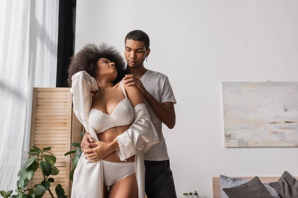 Young African American Man Embracing Curly Girlfriend Wearing Sexy Lingerie — Stockfoto
