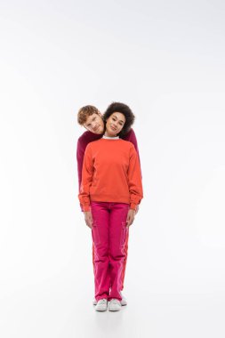 cheerful interracial couple in magenta color clothes showing i letter on white background  clipart