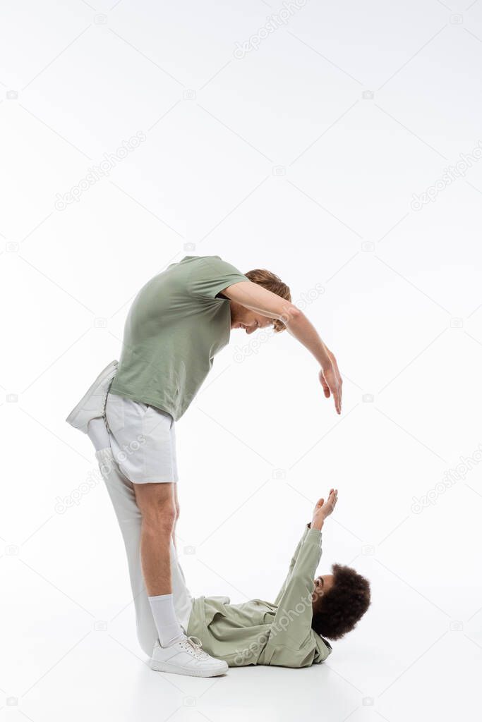 Side view of multiethnic couple showing c letter with hands on white background