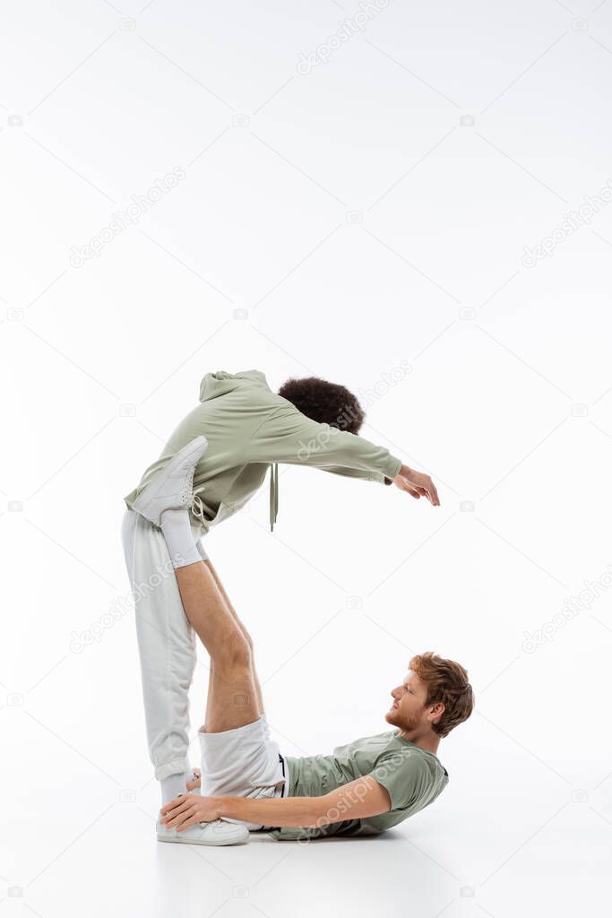 Side view of multiethnic man and woman showing c letter with hands on white background