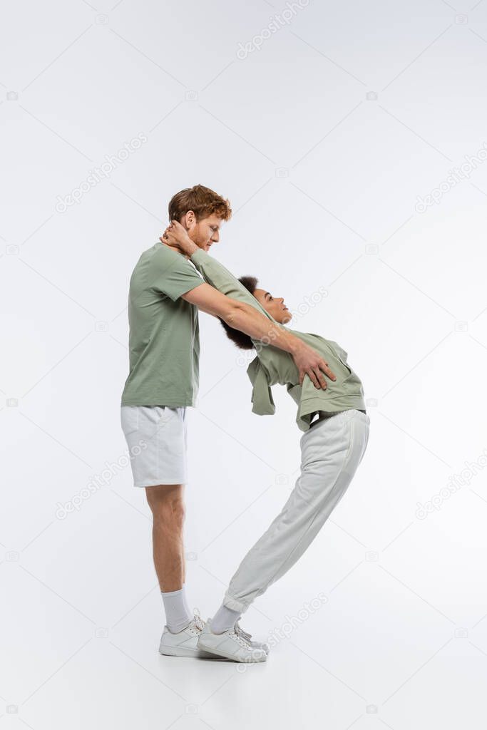 Side view of interracial couple showing d letter with bodies on white background
