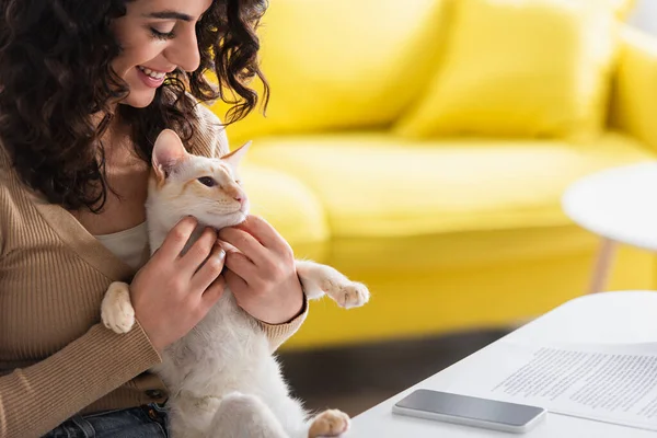 Smiling Copywriter Petting Oriental Cat Smartphone Papers Home — Stockfoto