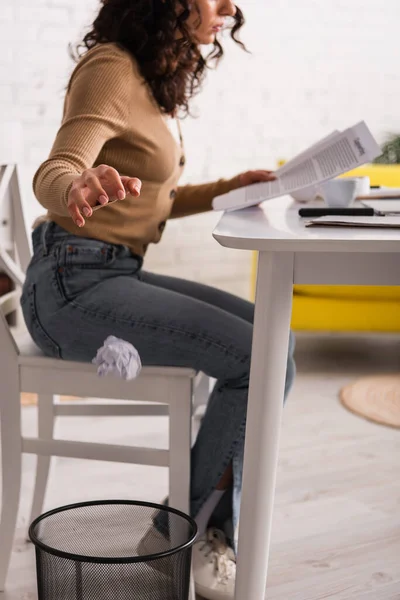 stock image Cropped view of blurred copywriter throwing crumpled paper in trash can at home 