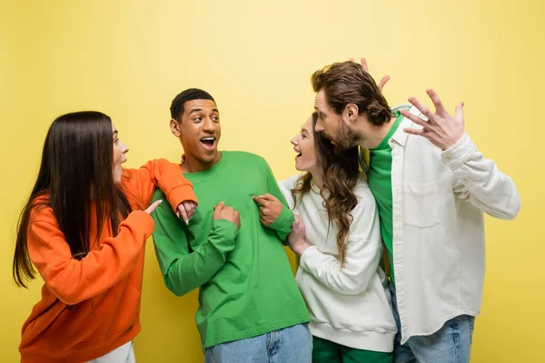 stock image Amazed friends looking at african american man on yellow background 