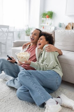 Patlamış mısırlı heyecanlı Afro-Amerikan çift evde komedi filmi izliyor. 