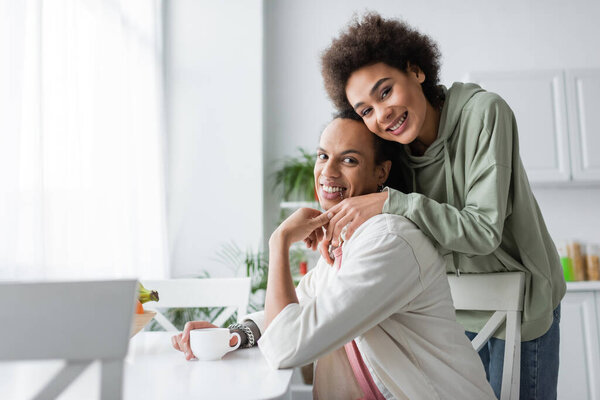 Африканская американская пара держит за руки кофе на кухне 