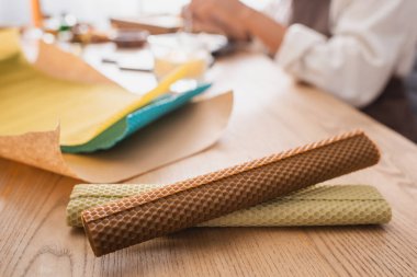 rolled wax sheets near cropped african american woman in craft workshop on blurred background