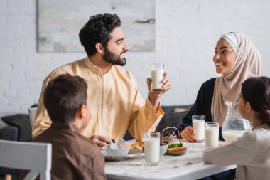 Smiling middle eastern family talking during ramadan breakfast at home  clipart