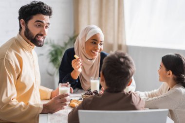 Müslüman baba, Suhur kahvaltısı sırasında mutlu bir ailenin yanında oğluyla konuşuyor. 