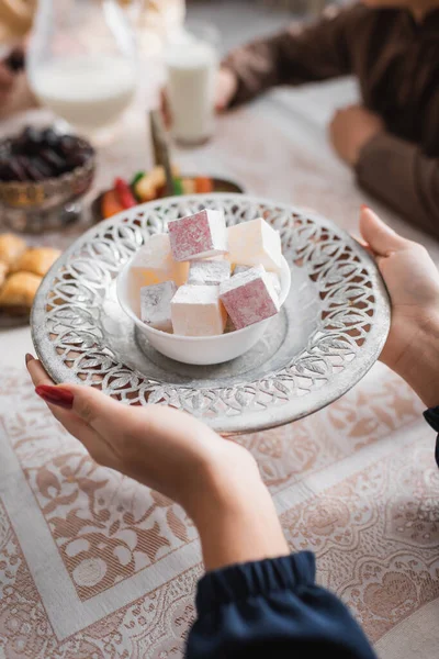 stock image Cropped view of muslim woman holding tasty turkish delight near food during ramadan in morning 