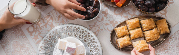 Top view of muslim mother and kids having breakfast during suhur at home, banner 
