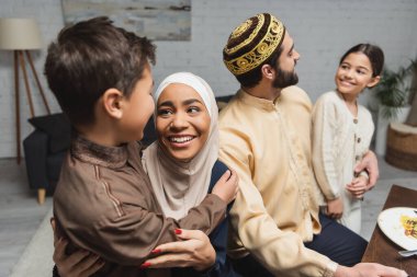 Gülümseyen Orta Doğulu ebeveynler Ramazan 'da evlerinde kızlarına ve oğullarına sarılıyorlar. 