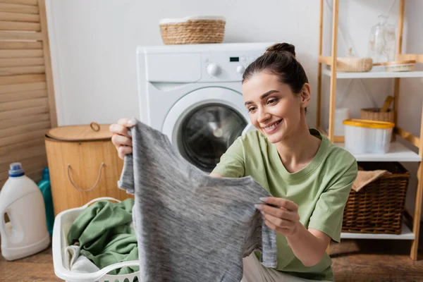 Positive Brunette Woman Holding Blurred Shirt Laundry Room — Foto de Stock