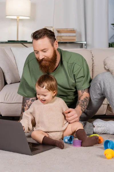Bearded Dad Using Laptop Daughter Toys Home — Φωτογραφία Αρχείου