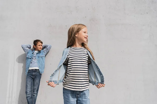 Cheerful Girl Denim Outfit Standing Well Dressed Boy Blurred Background — Foto de Stock